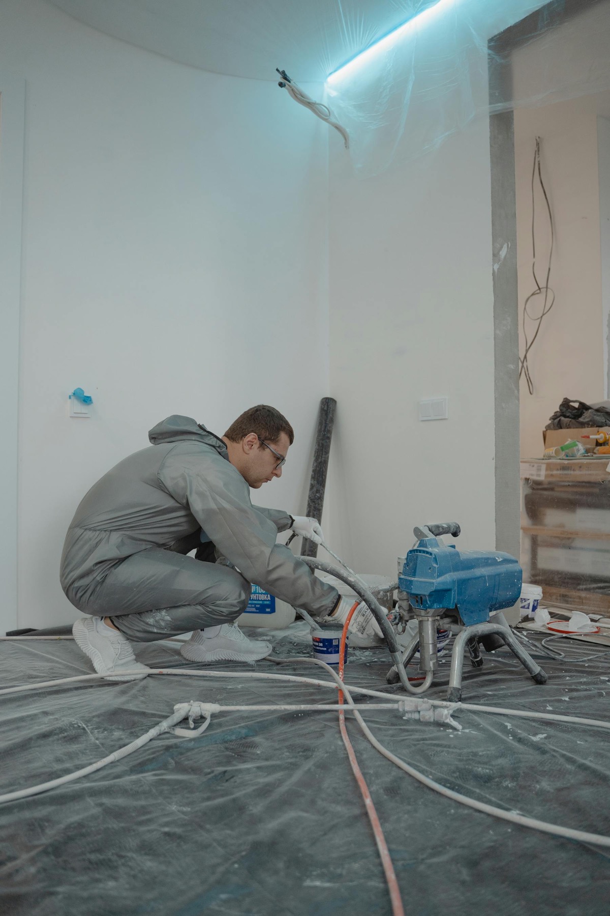 Restoration technician setting up drying equipment inside a damaged room